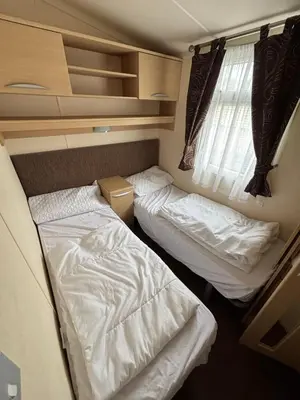 two beds in a small room with a window at The Beach Hideaway Pet Friendly 2 Bedroom Static Caravan Clarach Bay in Aberystwyth