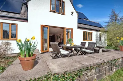 a patio with a table and chairs in front of a house at Finest Retreats - Cwmfron House in Llanidloes