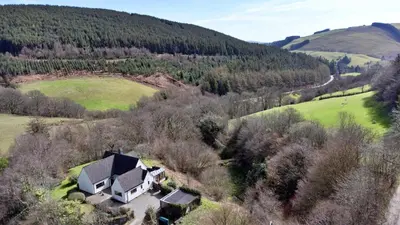 an aerial view of a house in a field at Finest Retreats - Cwmfron House in Llanidloes
