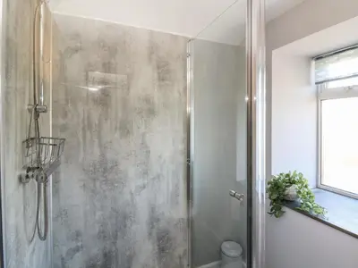 a shower with a glass door in a bathroom at Curtau in Builth Wells