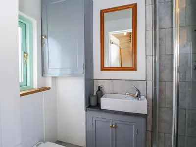 a bathroom with a sink and a mirror at Gilberry Shepherds Hut in Church Stretton