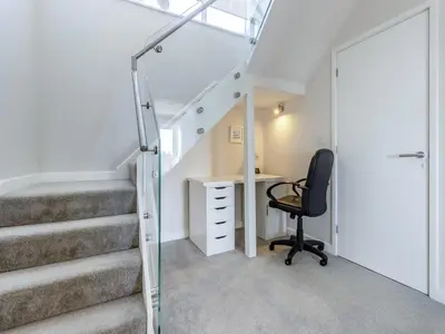 an office with a desk and a chair next to a staircase at Verbier Luxurious Seaside Retreat in Aberdyfi
