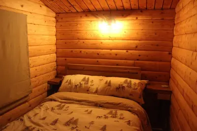 a room with a bed in a log cabin at Beautifully Restored Log Cabin in Trawsfynydd