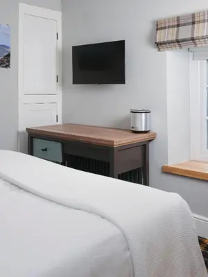 a bedroom with a bed and a table with a tv at The Bryntirion Inn in Llandderfel
