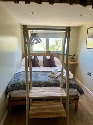 a bedroom with a bed with a wooden bed frame at Peaceful Dyfi Valley Cottage - Hendre-gau in Machynlleth