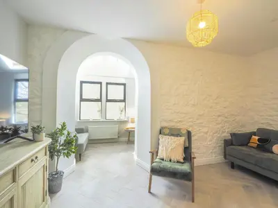 a living room with a couch and a chair at Ceirios Wen Aberaeron in Llanarth