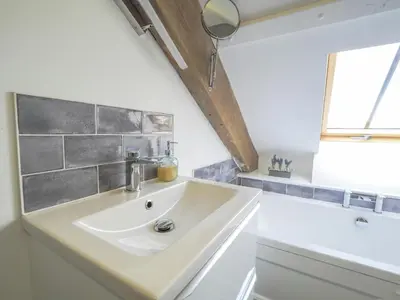 a bathroom with a sink and a bath tub at Ceirios Wen Aberaeron in Llanarth