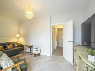 a living room with a couch and a table at Ceirios Wen Aberaeron in Llanarth