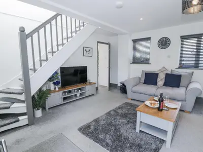a living room with a couch and a tv at The Coach House in Dolgellau