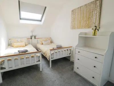a bedroom with two beds and a dresser at The Coach House in Dolgellau