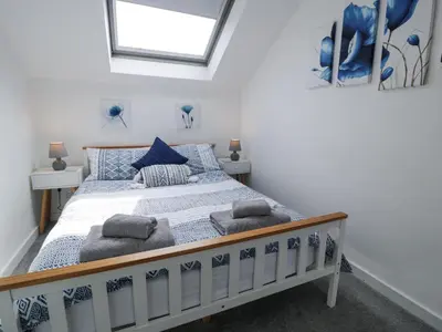 a bedroom with a bed with blue pillows at The Coach House in Dolgellau