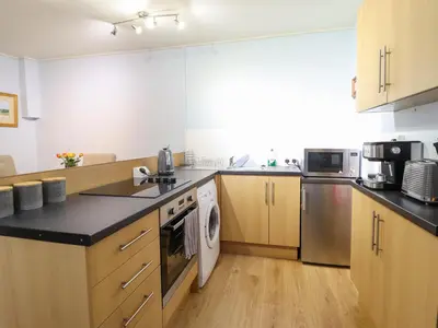 a large kitchen with wooden cabinets and appliances at Beach Haven in Aberystwyth