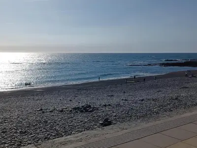 a beach with people on the sand and the ocean at Beach Haven in Aberystwyth