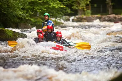 a group of people in a raft in a river at Ty-Mawr in Llanuwchllyn