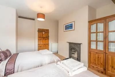 a bedroom with two beds and a fireplace at Ty-Mawr in Llanuwchllyn