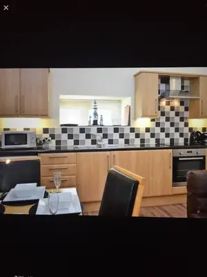 a kitchen with a table and a kitchen with a table and chairs at Coastal Bliss Charming Cottage near Borth beach in Borth
