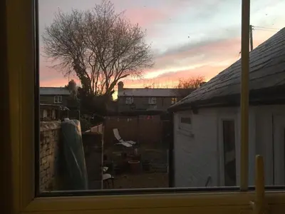 a view of a sunset from a window at Cosy Cottage in Kington