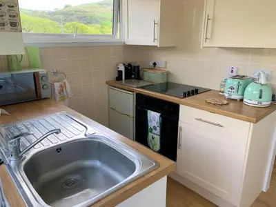 a kitchen with a sink and a counter top at Delightful Chalet Peaceful Site Near Aberdyfi in Tywyn