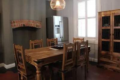 a kitchen with a wooden table and a refrigerator at Charming 4-Bed in Llangollen in Llangollen
