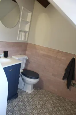 a bathroom with a toilet and a sink and a mirror at Charming 4-Bed in Llangollen in Llangollen