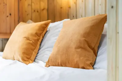 a bed with two brown pillows on it at Off-Grid Glamping - Quiet, Starry Escape in Yarpole