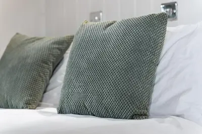 two green pillows sitting on top of a bed at Hot Tub Luxury Glamping - Private Stargazing Patio in Yarpole