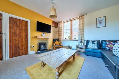 a living room with a wooden table and a blue couch at Finest Retreats - Yr Daflod in Brecon