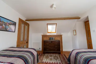 a bedroom with two beds and a dresser at Coach House in Llanwrtyd Wells