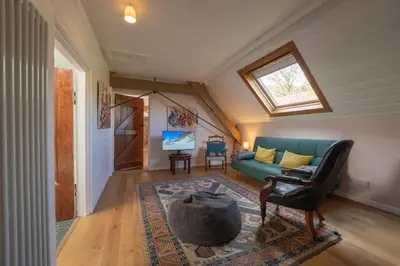 a living room with a green couch and a window at Coach House in Llanwrtyd Wells