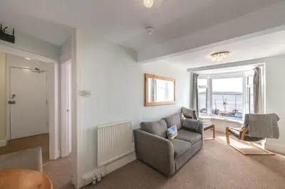 a living room with a couch and a chair at Aberdyfi Sea View Apartment in Aberdyfi