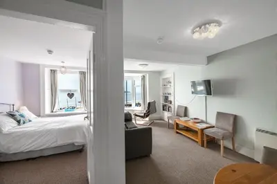 a bedroom with a bed and a living room at Aberdyfi Sea View Apartment in Aberdyfi