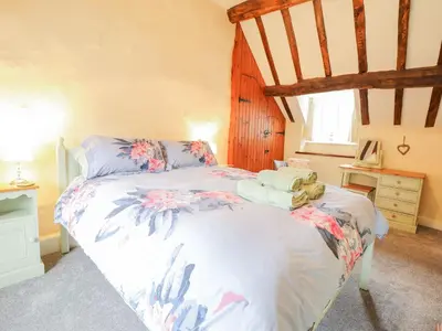a bedroom with a bed with flowers on it at Ty Glan Yr Afon in Dolgellau