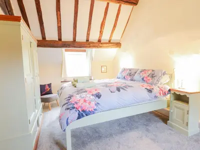 a bedroom with a bed with a blue comforter and a window at Ty Glan Yr Afon in Dolgellau