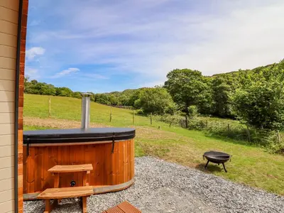 a hot tub and a grill on the side of a house at Briallen in Dolgellau