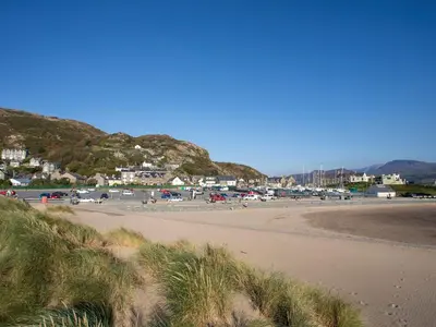 a sandy beach with a town in the background at Briallen in Dolgellau