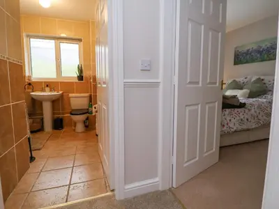 a bathroom with a sink and a toilet and a bed at 2 Mountain View in Wrexham