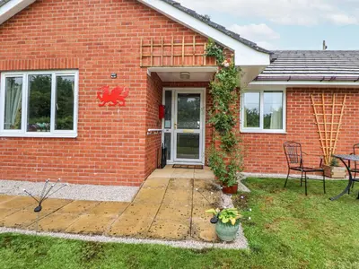 a red brick house with a door and a patio at 2 Mountain View in Wrexham