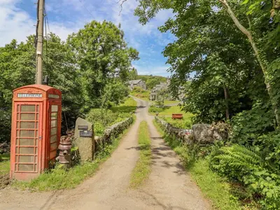 a red phone booth on the side of a dirt road at Dwynant in Dolgellau