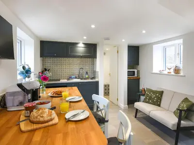 a kitchen and living room with a wooden table with food on it at The Little House - Uk49129 in Stapleton