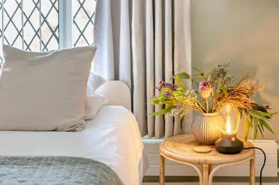 a bed with a table with a vase with flowers on it at 2 Bed in Ludlow oc-c31883 in Ludlow