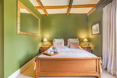 a bedroom with a bed with green walls and a mirror at 2 Bed in Ludlow oc-s31884 in Ludlow