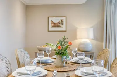 a table with plates and glasses and a vase with flowers at 2 Bed in Ludlow oc-p31882 in Ludlow