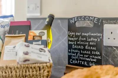 a table with a bottle of wine and a basket of food at 2 Bed in Ludlow oc-d31885 in Ludlow