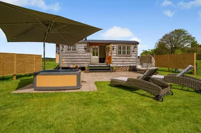 a backyard with a house and an umbrella and chairs at 1 Bed in Brecon oc-t31948 in Bronllys