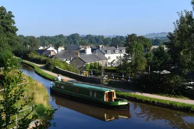 a green boat on a river in a town at 1 Bed in Brecon oc-t31948 in Bronllys