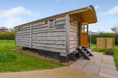 a small wooden cabin with a bench in a yard at 1 Bed in Brecon oc-t31948 in Bronllys