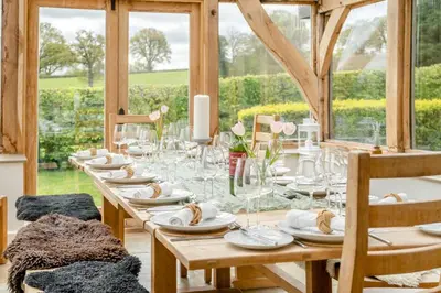 a dining room with a long table with chairs and windows at 6 Bed in Llanwern oc-w31947 in Brecon