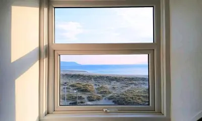 an open window with a view of the beach at Seashell Apartment in Barmouth