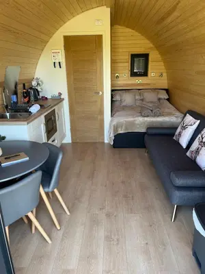 a room with a bed and a table and a couch at Mynd View Pods Cedar in Craven Arms