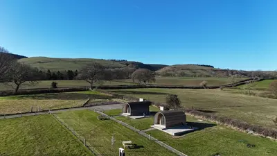 an aerial view of a field with two buildings at Mynd View Pods Cedar in Craven Arms